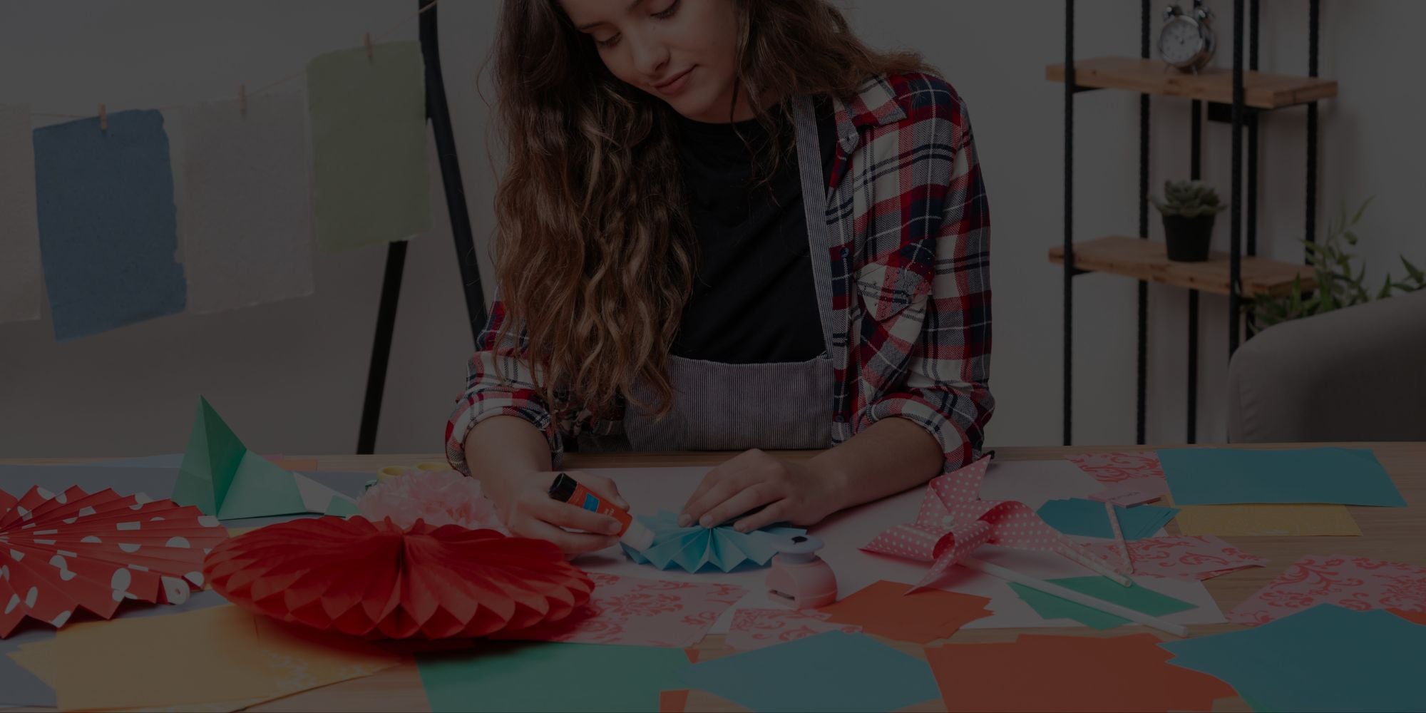 Person working on a craft project with colorful paper at a table.